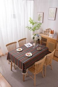Detailed overhead view of Bohemian striped tablecloth with white decorative cotton tassels