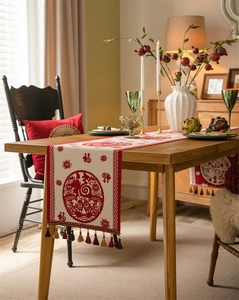 Detail of Chinese New Year table runner with Fu character jacquard and festive tassels