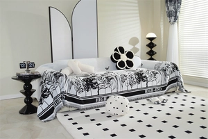 Detail of high-end chenille sofa cover with black and white tropical leaf pattern and tassels