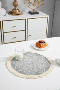 Détail d'un set de table bohème rond avec motif mandala bleu et bordure à franges