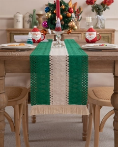Detail of green and white woven cotton table runner with tassels and hollow mesh texture