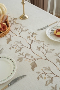 Detail of leaf embroidery on linen fabric with vintage beige and brown textures