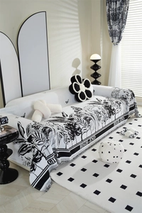 Detail of chenille sofa cover showing black and white tropical palm leaves and fringe edges