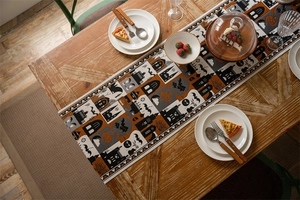 Detailed view of Halloween table runner with pumpkin patterns on wooden dining table