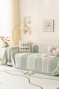 Close-up of chenille throw blanket featuring sage green geometric patterns and soft fringes