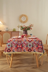 Detail of vintage bohemian tablecloth with colorful geometric patterns and gold tassels