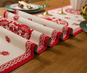Detail of Chinese New Year table runner featuring red jacquard floral patterns on cream fabric
