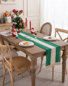 Detail of hand-woven striped table runner with beige tassels and crochet hollow patterns