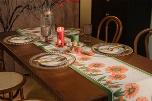 Dettaglio del runner da tavola moderno con margherite arancioni e nappe a onde