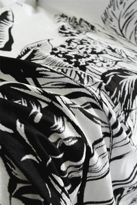 Close-up of black and white floral chenille jacquard fabric with thick knit texture