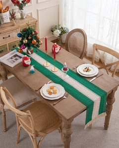 Macro detail of Christmas table runner with green stripes, woven texture and beige tassels