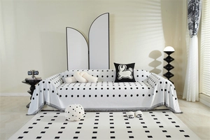 Detail of white chenille sofa throw with black polka dots and decorative fringe edge