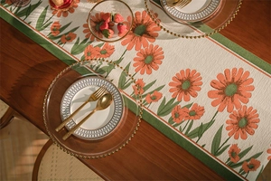 Dettaglio del runner da tavola jacquard con margherite arancioni e nappe decorative