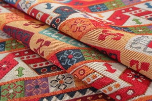 Macro shot of colorful geometric jacquard weave with vintage floral patterns and tassels