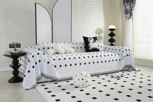 Detail of white chenille sofa throw with black polka dots and fine grey fringe edges
