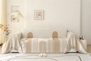 Detail of Nordic chenille sofa throw featuring geometric arch patterns and fringe edges