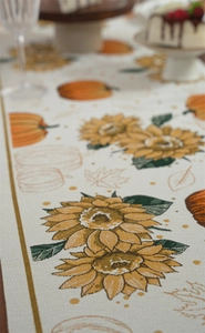 Macro view of jacquard woven table runner featuring autumn sunflowers and pumpkins
