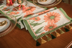 Vista dettagliata del runner da tavola jacquard con margherite e nappe colorate