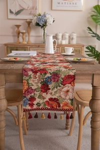 Macro shot of colorful floral jacquard table runner with decorative bohemian fringe tassels