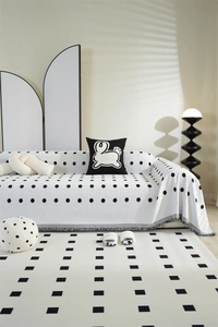 Detail of chenille sofa cover with black polka dots and delicate grey fringe trim