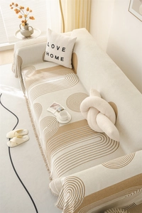 Close-up of chenille sofa throw featuring geometric jacquard patterns and fringe edges