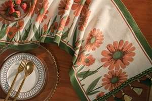 Dettaglio della trama del runner jacquard con motivi a margherite arancioni e frange