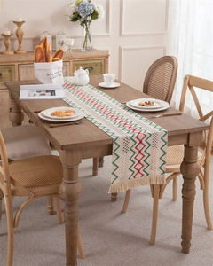 Close-up of woven cotton linen table runner with red green wavy patterns and fringe