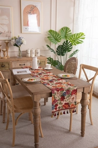 Detail of vintage floral table runner with red tassels and jacquard woven fabric texture
