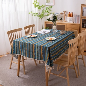 Bohemian striped tablecloth with gold stamping and tassels on a cozy wooden table
