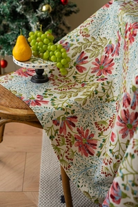 Detail der Vintage-Jacquard-Tischdecke mit Blumenmuster und Quasten auf Holzstuhl