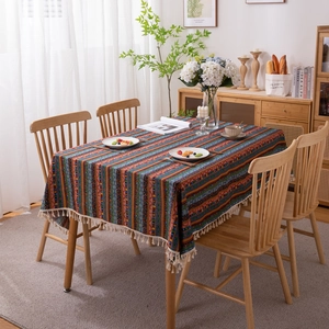 Bohemian striped tablecloth with gold stamping and tassels on a wooden dining table