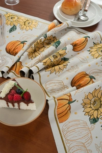 Detailed jacquard weave table runner featuring sunflowers and harvest pumpkins on wood