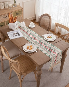Close-up of woven cotton linen table runner with red and green chevron stripes and tassels