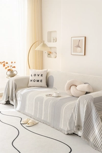 Close-up of Nordic chenille sofa cover showing grey geometric patterns and fringe edges