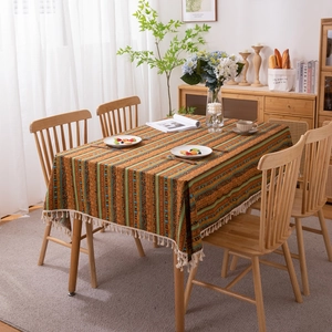 Bohemian striped tablecloth with fringe, ethnic geometric pattern on wooden dining table