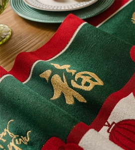 Detail of red and green jacquard table runner with golden Fu character and embroidery