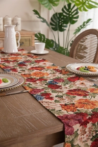 Close-up of vintage floral jacquard table runner with fringe on a wooden dining table