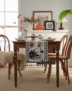 Detail of Halloween table runner featuring pumpkin, castle, and bat motifs with tassels