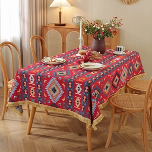 Vintage American jacquard tablecloth with floral patterns and golden tassels on wood table