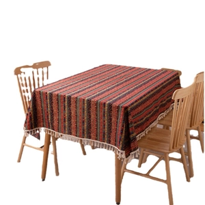 Bohemian striped tablecloth with gold stamping and tassels on a wooden dining table