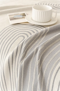 Detail of Nordic chenille throw cover with blue geometric arch pattern on cream fabric