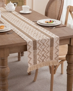 Detail of hand-woven cotton linen table runner with zigzag pattern and fringe tassels
