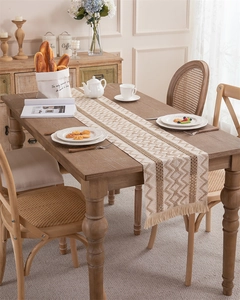 Detailed close-up of woven cotton linen table runner with geometric patterns and fringe