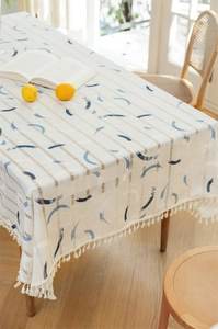 Detailaufnahme der blauen Drucke und weißen Fransen auf der cremefarbenen Tischdecke