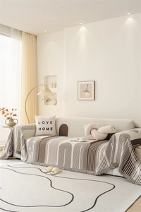 Detail of Nordic chenille sofa throw featuring beige geometric patterns and fringe edges