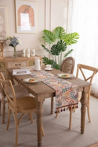 Close-up of vintage floral table runner with colorful jacquard patterns and tassels