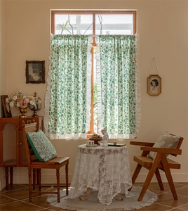 Close-up of floral cotton cafe curtains with ruffles in a rustic vintage kitchen setting