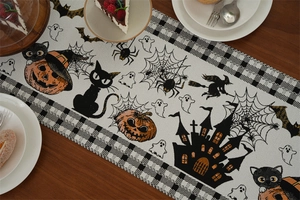 Close-up of Halloween table runner with pumpkin and ghost motifs on woven fabric