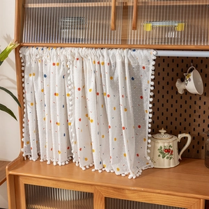 Detailed texture of white cotton cafe curtain with colorful dots and pom-pom trim edges