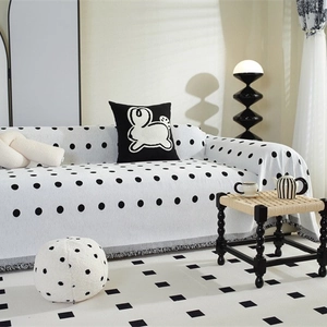 Nordic chenille sofa cover with black polka dots and grey fringe in a modern room